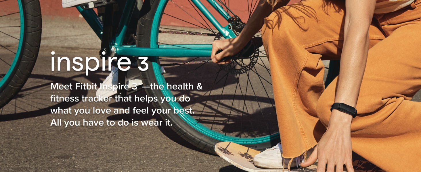 person in orange pants kneeling in front of green bicycle